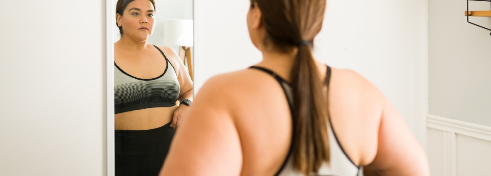 Woman looking at herself in the mirror after workout 